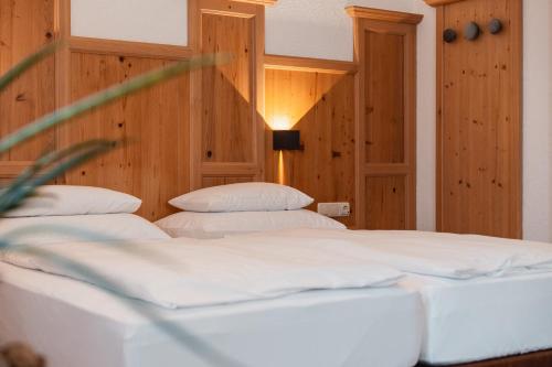 two beds in a room with wood paneling at Schindler in Sankt Anton am Arlberg