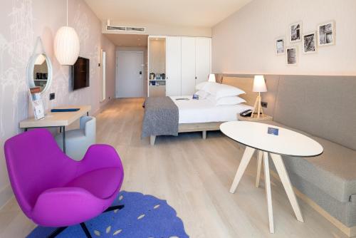 a hotel room with a bed and a purple chair at Radisson Blu Resort & Spa in Split