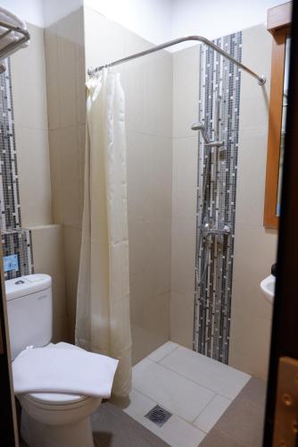 a bathroom with a toilet and a shower at Point C Hotel in Bandung