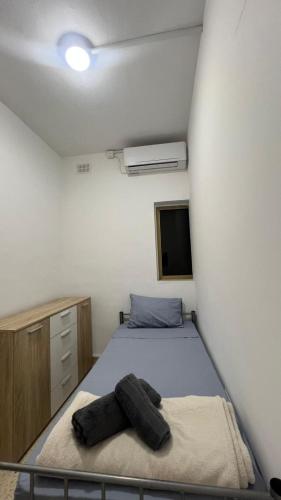 a bedroom with a bed and a white wall at Private Room in San Ġwann