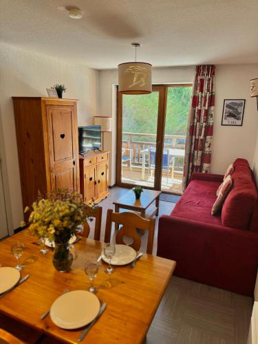 un salon avec une table et un canapé dans l'établissement Appartement Vars sur les pistes de ski avec piscine, à Sainte-Marie-de-Vars