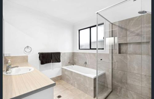 a bathroom with a tub and a sink and a shower at Family-Perfect Home Relax, Swim, Explore, Repeat! in Palmview