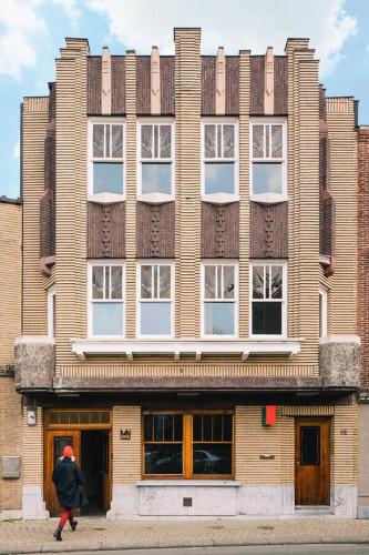 a person walking in front of a large building at Huis Hector Mechiels HOUSE in Lindeken
