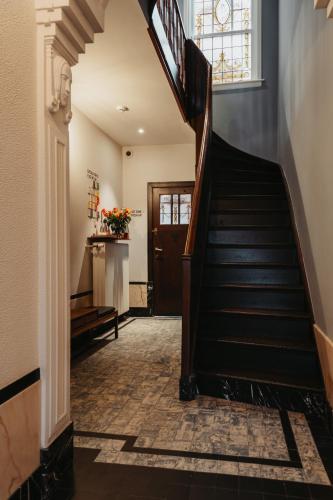 a hallway with stairs leading to a door at Huis Hector Mechiels HOUSE in Lindeken
