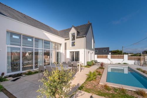 une maison avec une piscine dans une cour dans l'établissement Les Palissades - La mer du bon côté, à Saint-Pierre-Quiberon