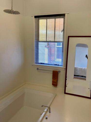 a white bathroom with a sink and a mirror at Huis Hector Mechiels HOUSE in Lindeken