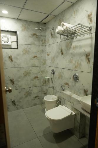 a bathroom with a toilet and a sink at Hotel Amrut Inn Hospitalities in Somnath