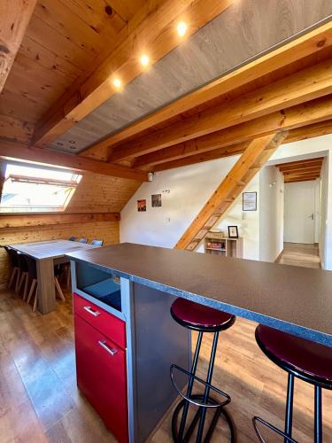 une cuisine avec un comptoir et des tabourets dans une pièce dans l'établissement Chez Fred 201 - Parking Wifi - CLG Savoie, à Chevillard