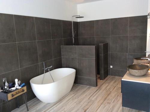 une salle de bain avec une baignoire blanche et un lavabo dans l'établissement Villa aloha, à Saint-Rémy-de-Provence
