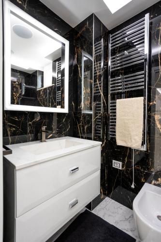 a bathroom with a white sink and a mirror at Suite Tropea in Tropea