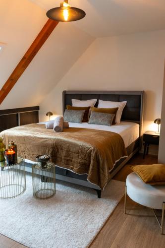 une chambre avec un grand lit dans un grenier dans l'établissement LES GRANGES DE JADIS ALSACE Bis, à Holtzwihr