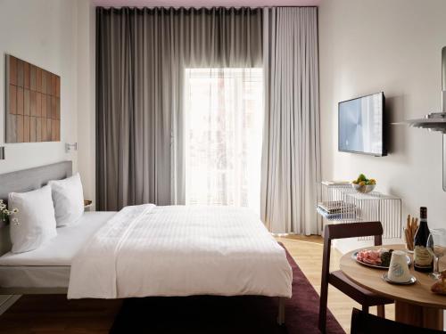 a bedroom with a bed and a table and a window at Mekano Apartment Hotel in Copenhagen