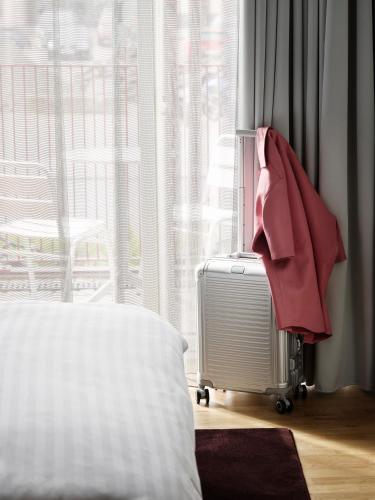 a bedroom with a suitcase in front of a window at Mekano Apartment Hotel in Copenhagen