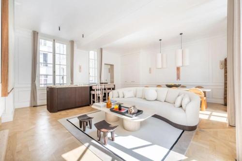 un salon avec un canapé blanc et une table dans l'établissement Appartement de luxe Marais, à Paris