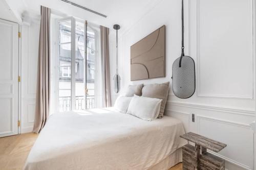 une chambre blanche avec un lit et une fenêtre dans l'établissement Appartement de luxe Marais, à Paris