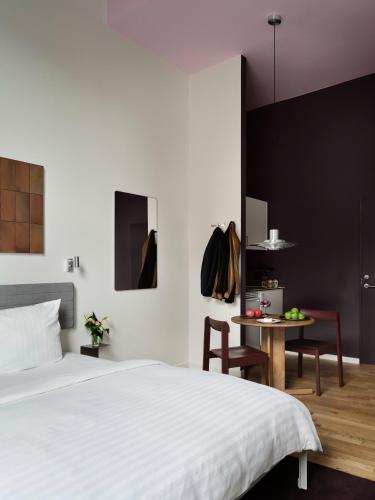 a bedroom with a large bed and a table at Mekano Apartment Hotel in Copenhagen