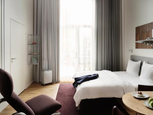a bedroom with a bed and a table and a chair at Mekano Apartment Hotel in Copenhagen