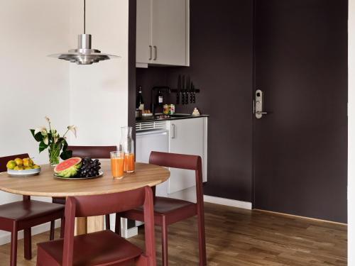 a kitchen with a table and chairs with a bowl of fruit at Mekano Apartment Hotel in Copenhagen