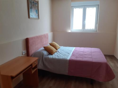 a bedroom with a bed with a desk and a window at Casa Juan in Barrantes
