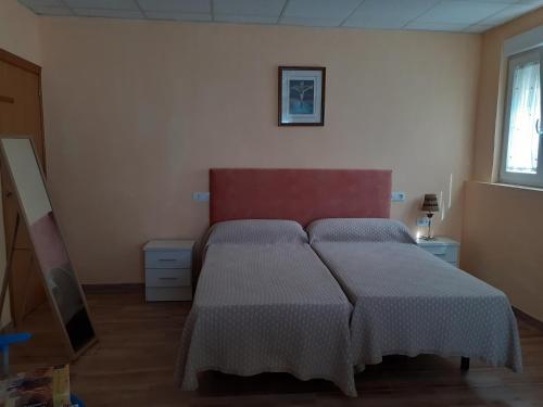 a bedroom with a bed with a red head board at Casa Juan in Barrantes