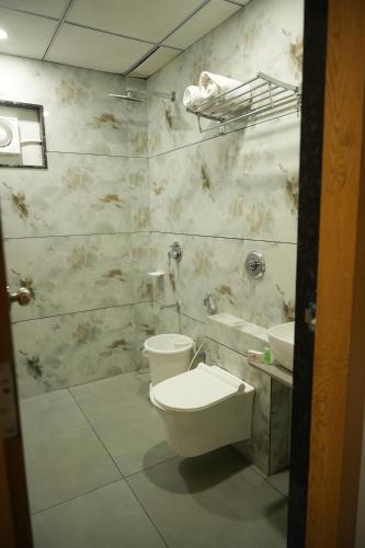 a bathroom with a toilet and a sink at Hotel Amrut Inn Hospitalities in Somnath