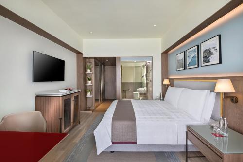 a hotel room with a bed and a television at Trident Nariman Point in Mumbai