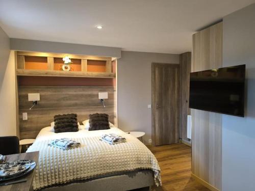 a bedroom with a bed and a flat screen tv at Grand Studio Place Morny refait à neuf in Deauville