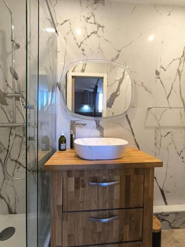 une salle de bain avec un lavabo et un miroir dans l'établissement Grand Studio Place Morny refait à neuf, à Deauville