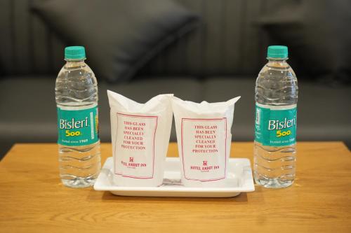 two bottles of bottled water and paper towels on a table at Hotel Amrut Inn Hospitalities in Somnath