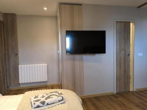 a bedroom with a flat screen tv on a wall at Grand Studio Place Morny refait à neuf in Deauville