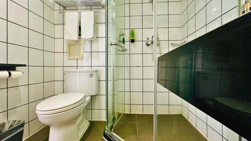 a bathroom with a toilet and a glass shower at Shanghai Zhongan Hotel Xizang North Road Subway Station Branch in Shanghai