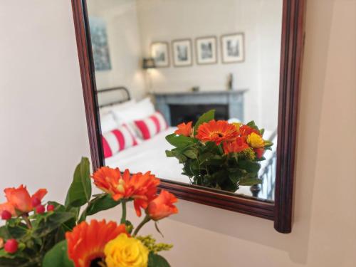 a mirror with a vase of flowers in front of a bedroom at Historic Winchester Apartment in Winchester