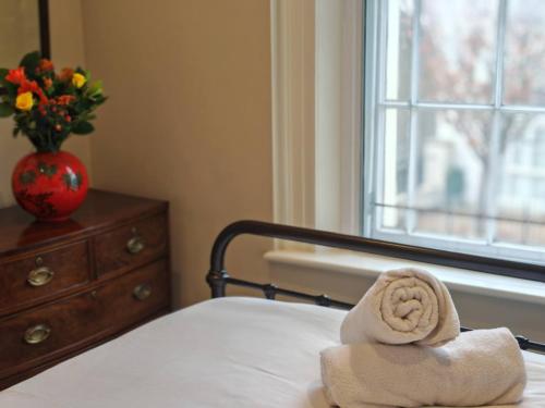 a towel sitting on top of a bed with a window at Historic Winchester Apartment in Winchester