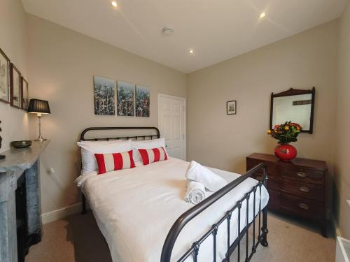 a bedroom with a bed with red and white pillows at Historic Winchester Apartment in Winchester