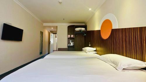 a bedroom with a large bed with white sheets at Shanghai Zhongan Hotel Xizang North Road Subway Station Branch in Shanghai