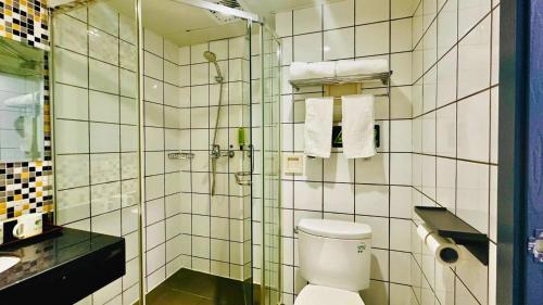 a bathroom with a toilet and a glass shower at Shanghai Zhongan Hotel Xizang North Road Subway Station Branch in Shanghai