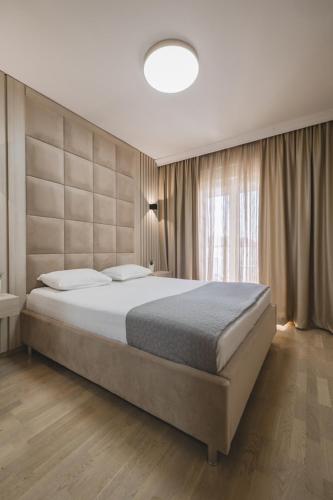 a bedroom with a large bed and a large window at Harmony Apartments in Podgorica