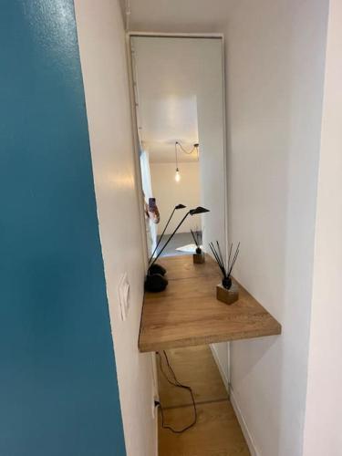 een kamer met een tafel met een spiegel en een lamp bij la maison d' antoine 2 in Chamalières