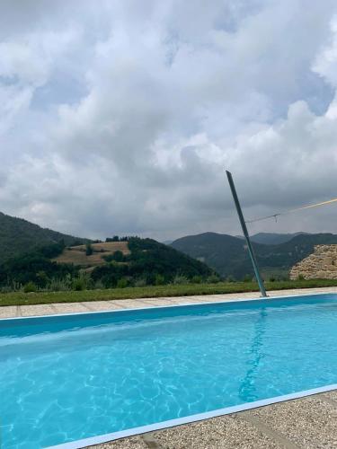 a blue swimming pool with mountains in the background at Podere Quartarola in Modigliana