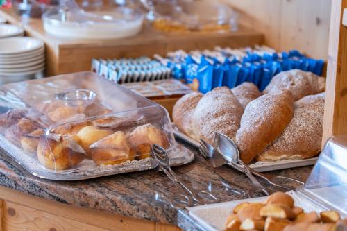 un panificio con pasticcini e pane sul bancone di Hotel Mary a Pozza di Fassa