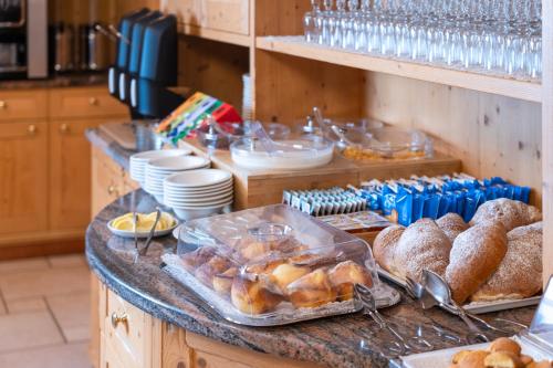 un buffet con pane e dolci su un bancone di Hotel Mary a Pozza di Fassa