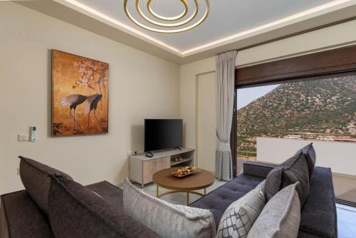 a living room with a couch and a tv at Brikis Villas - With 3 Private Pools in Balíon