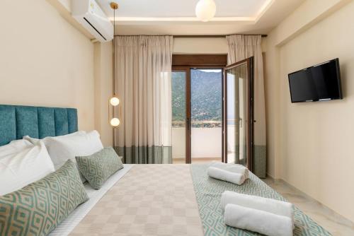 a bedroom with a bed with a television on the wall at Brikis Villas - With 3 Private Pools in Balíon