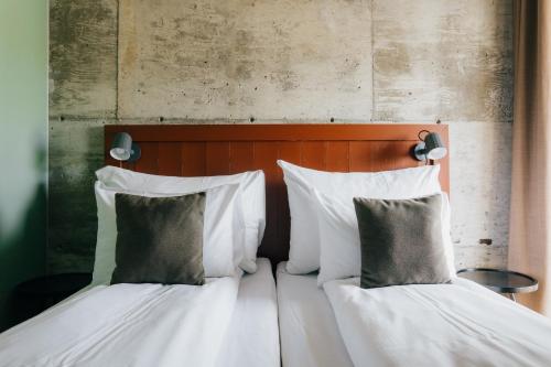two beds with white pillows sitting next to each other at GamlaVærket Gjæstgiveri og Tracteringssted in Sandnes