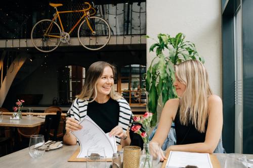 two women sitting at a table in a restaurant at GamlaVærket Gjæstgiveri og Tracteringssted in Sandnes