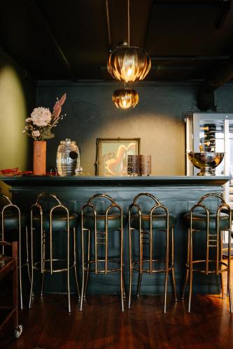 a bar with four stools in a room at GamlaVærket Gjæstgiveri og Tracteringssted in Sandnes