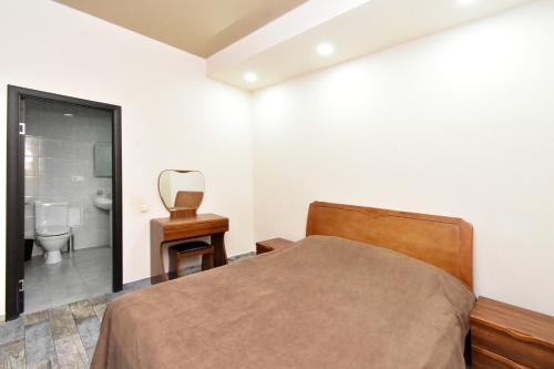 a bedroom with a bed and a mirror and a toilet at YARS Apartments in Yerevan