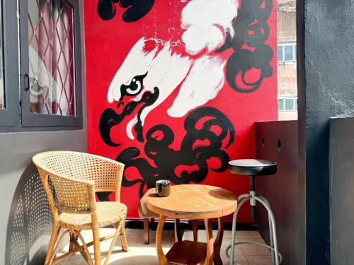 Ashi Poshtel في شيانغ ماي: طاولة وكراسي أمام جدار أحمر