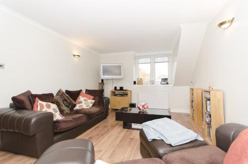 a living room with a couch and a tv at Aberdeen Quiet City Apartment, Ferryhill in Aberdeen