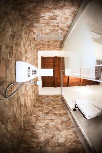 a bathroom with a stone wall at Domu Virginia in Castiadas